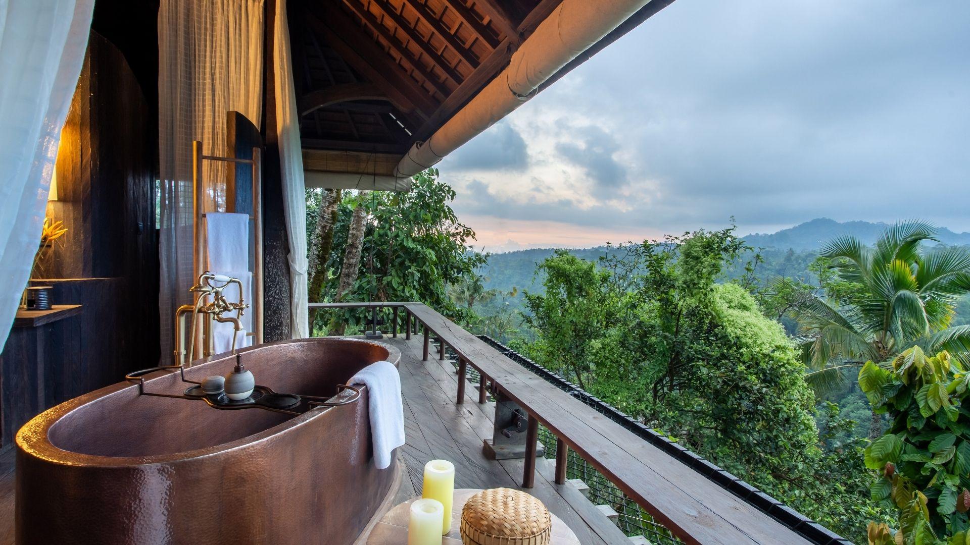 Bathtub positioned for lush forest view at Banyan Tree Escape - Buahan; calm, serene setting.