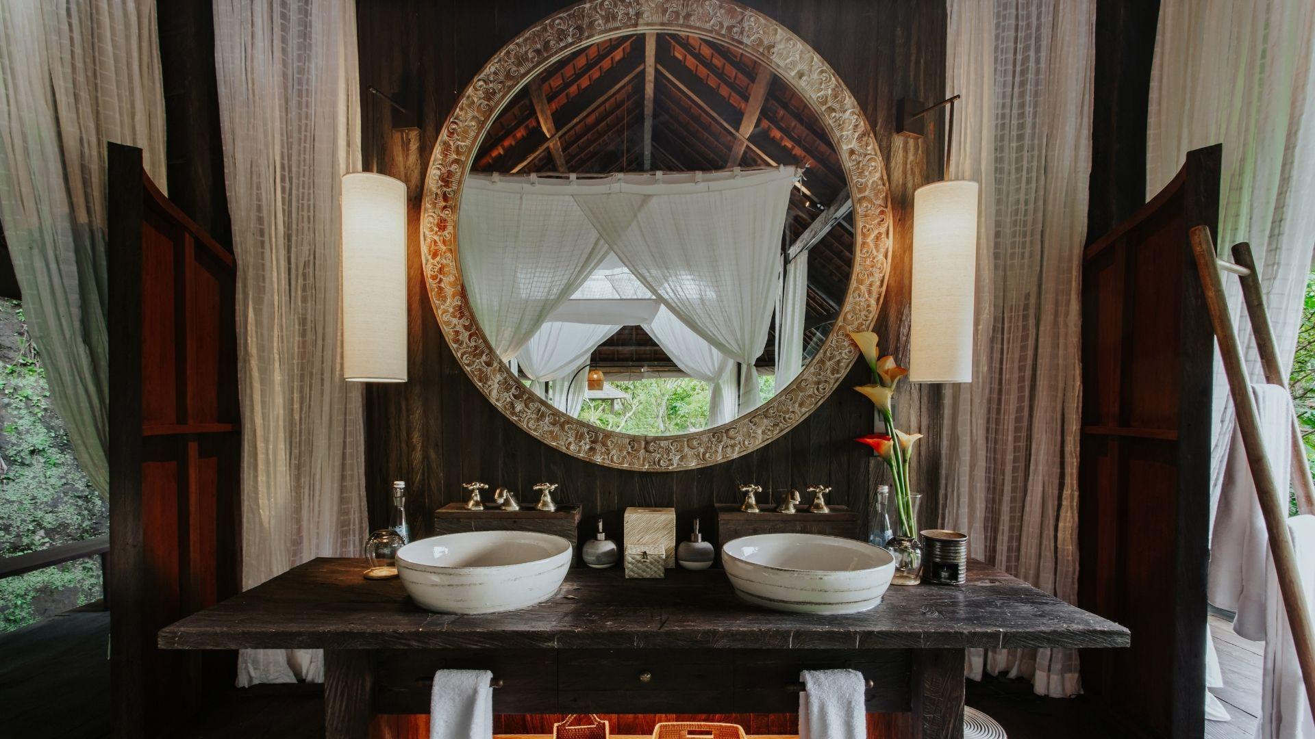 Elegant bathroom mirror reflecting tropical greenery, Banyan Tree Escape - Buahan's serene ambiance.