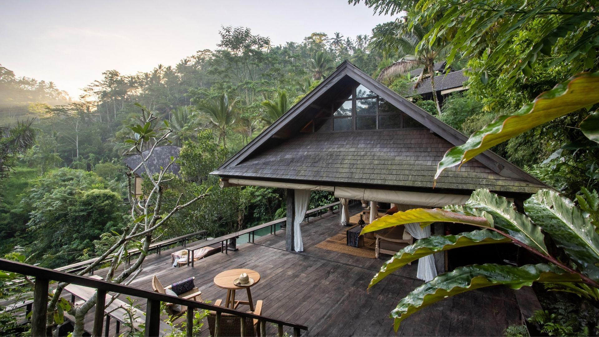 Eco-lodge patio offers serene forest view at Banyan Tree Escape - Buahan, blending seamlessly with nature.