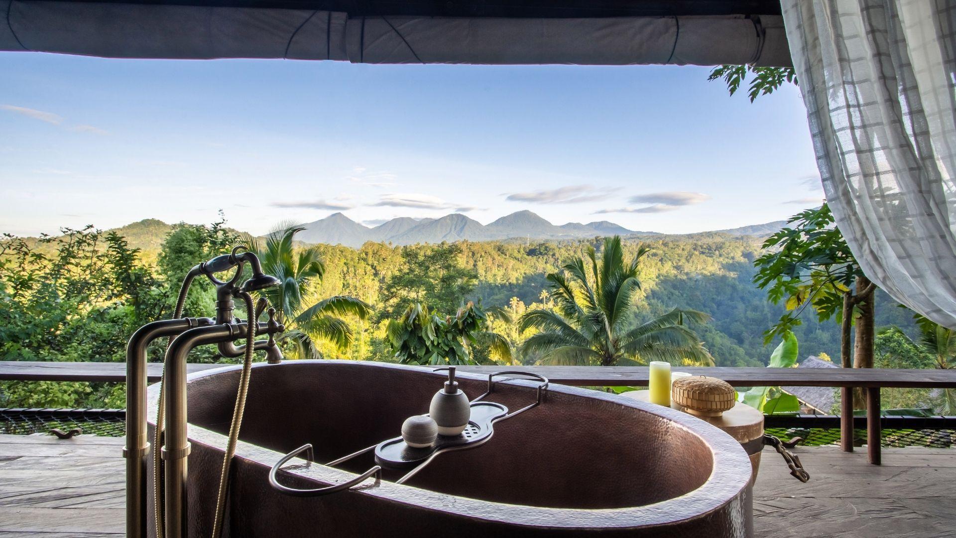 Copper tub overlooks lush forest and seven peaks mountains at Banyan Tree Escape - Buahan resort.