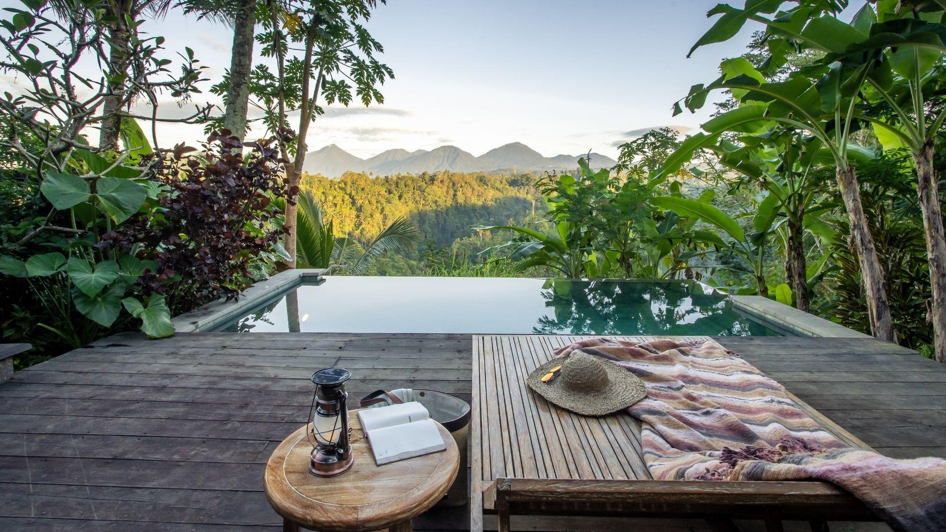 Rooftop deck with wooden lounge and pool overlooks lush mountains seven peaks  at Banyan Tree Escape - Buahan.