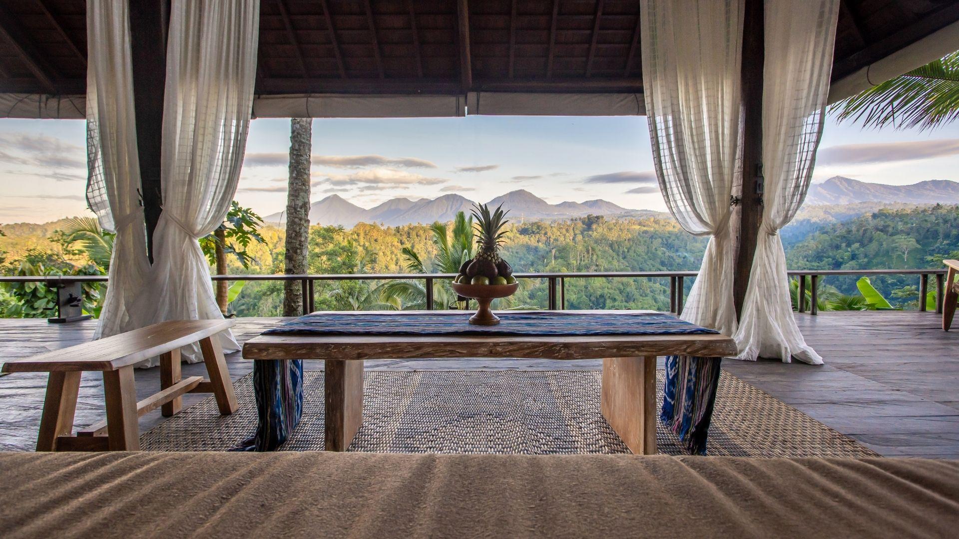 Fruit bowl sits on a table, overlooking seven peaks lush mountains at Banyan Tree Escape - Buahan.