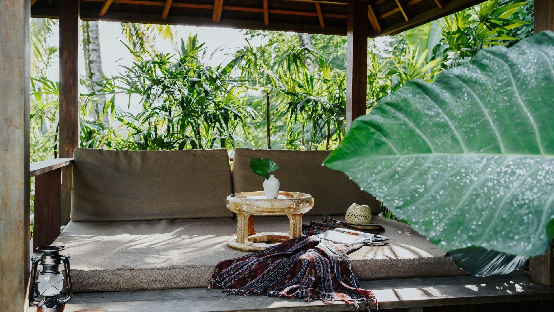 Lounge bed with cushions, surrounded by lush greenery & seven peaks views, at Banyan Tree Escape - Buahan.