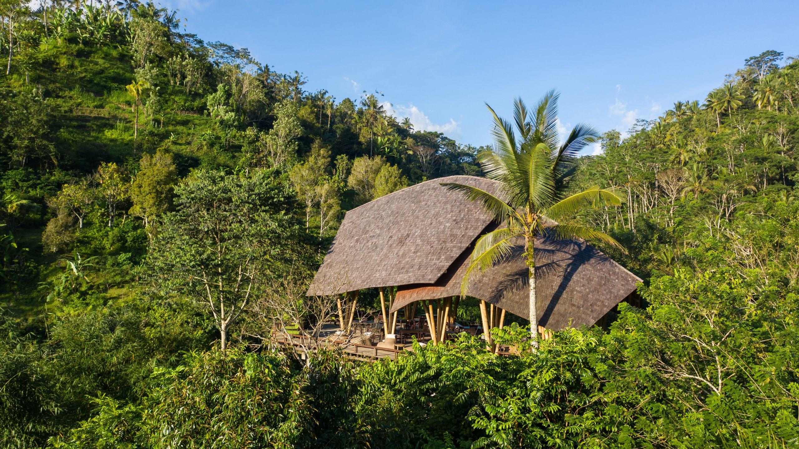 Thatched bamboo pavilion nestled in lush greenery at Banyan Tree Escape - Buahan.